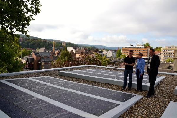 Das Foto zeigt von links nach rechts Thorsten Zöbelin, städtischer Fachbearbeiter Baumanagement, Marion Dammann, Bürgermeisterin Stadt Lörrach, Andreas Schneucker, städtischer Fachbereichsleiter Grundstücks- und Gebäudemanagement vor den vier neuen Solarmodulen auf dem Ratssaaldach. 